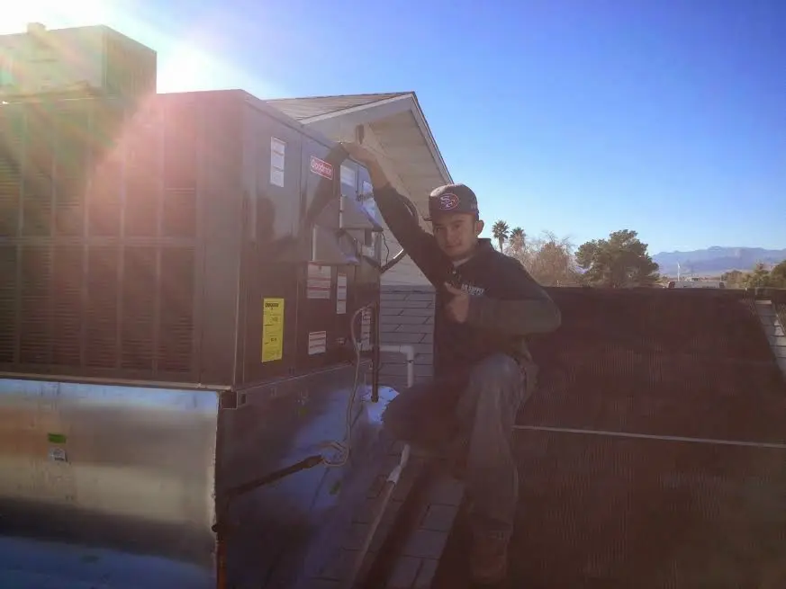 HVAC technician performing Heat Pump Repair on a rooftop unit in Selah